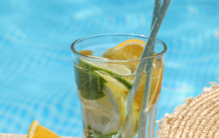 Getränk mit Früchten und Strohhalm am Pool.